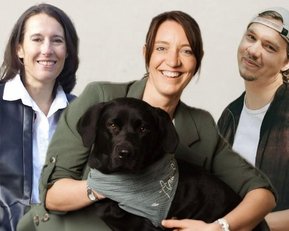 Drei Personen stehen zusammen, eine hält einen schwarzen Hund. Die Frauen tragen Blazer und die Männer lässige Kleidung.