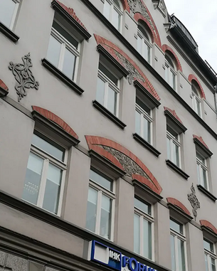 Fassade eines Gebäudes mit mehreren Fenstern und dekorativen Elementen. Das Schild "IHK FORUM" ist deutlich sichtbar. Die Architektur zeigt eine Kombination aus modernen und historischen Stilelementen.